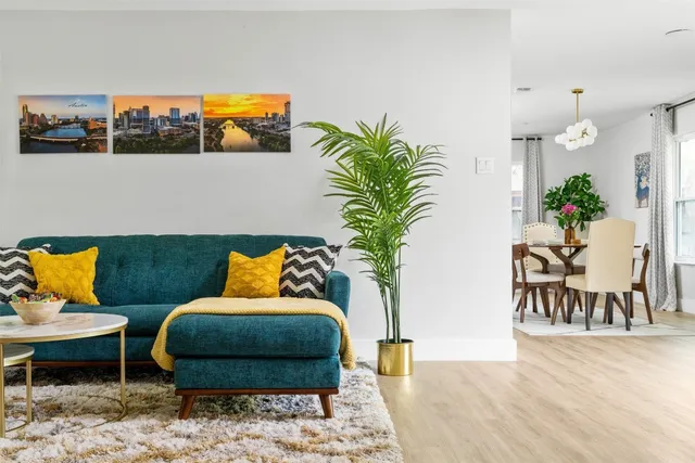 a living room with furniture potted plant and a table