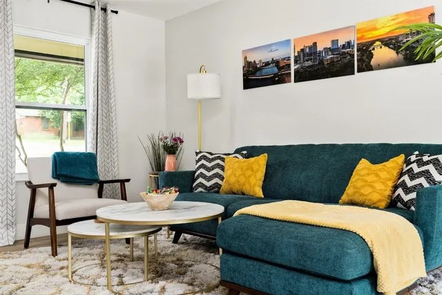 a bed sitting in a bedroom next to a window with a lamp and a table