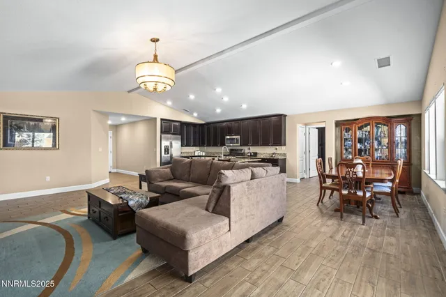 a living room with furniture kitchen view and a chandelier
