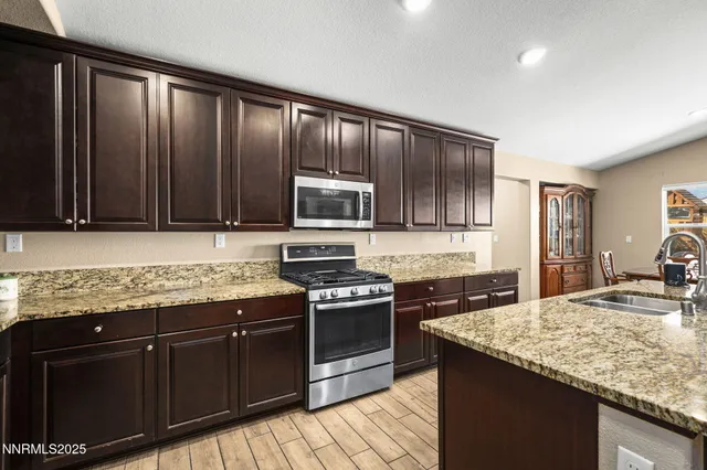 a kitchen with granite countertop stainless steel appliances and wooden cabinets