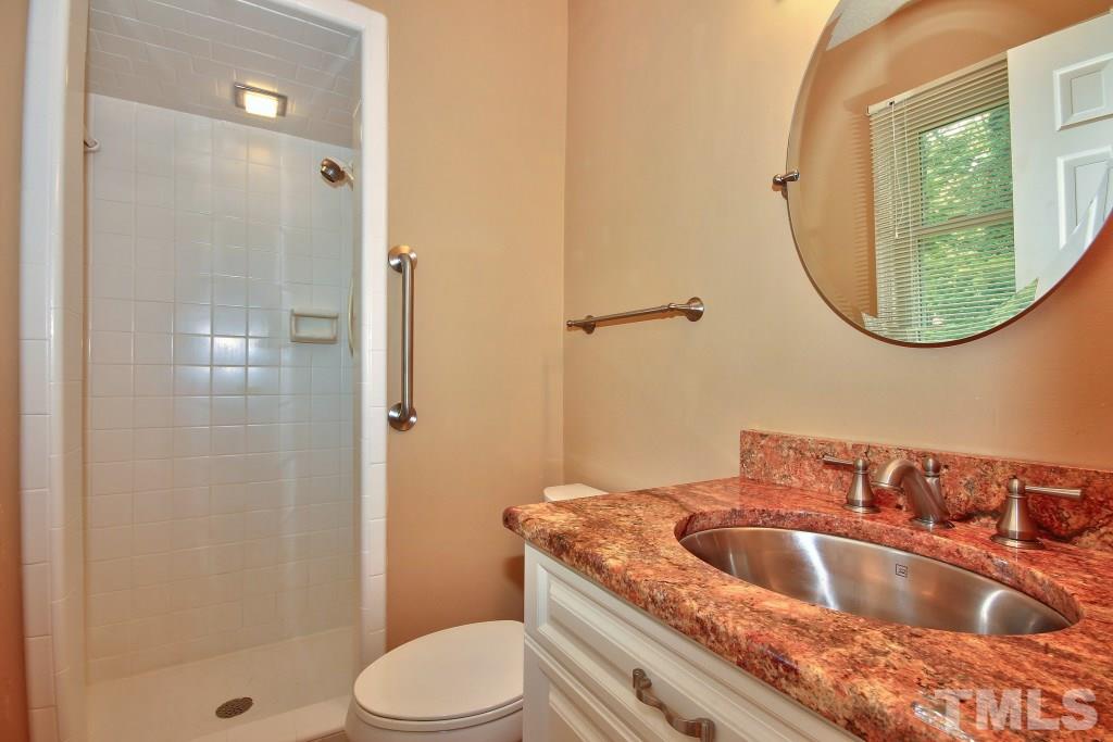 7609 Rambeau Circle Raleigh, NC 27613 - Photo 11 of 22 a bathroom with a granite countertop sink a toilet and shower