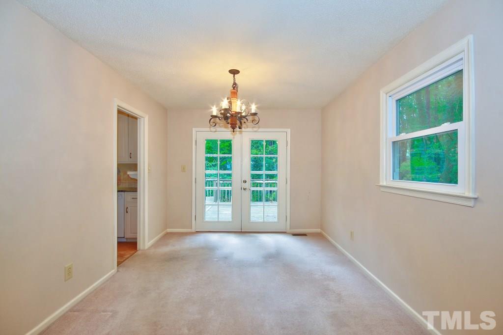 7609 Rambeau Circle Raleigh, NC 27613 - Photo 6 of 22 an empty room with windows and chandelier