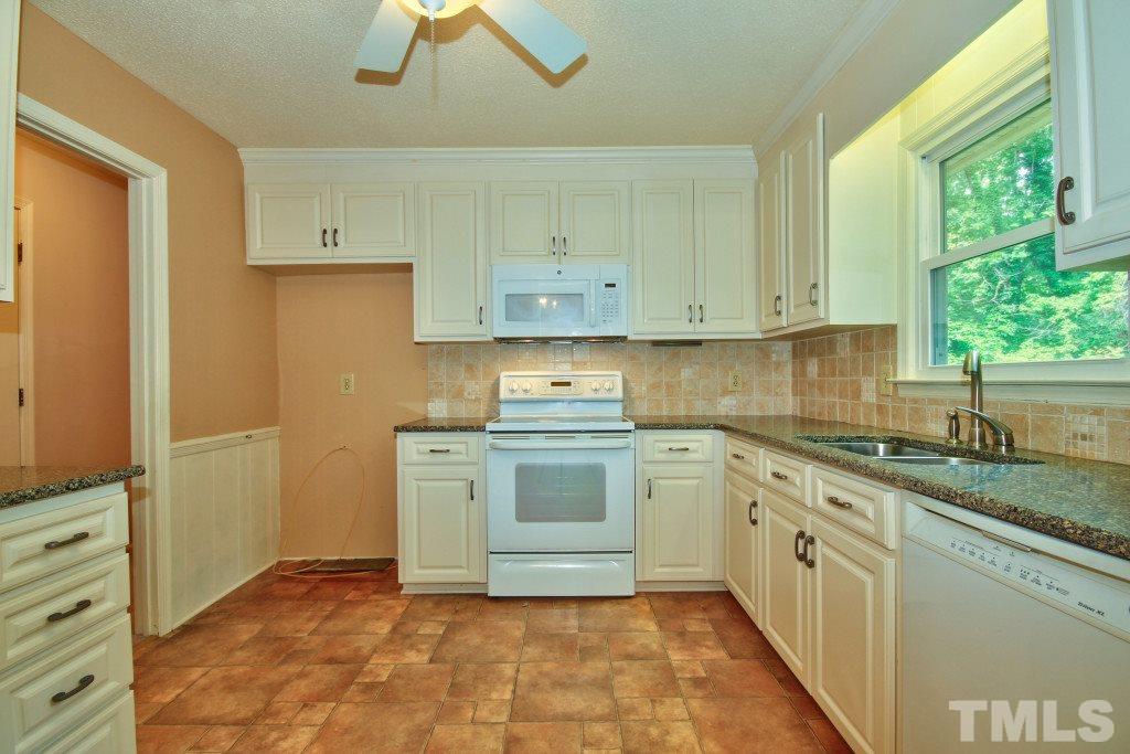 7609 Rambeau Circle Raleigh, NC 27613 - Photo 7 of 22 a kitchen with granite countertop white cabinets and white appliances