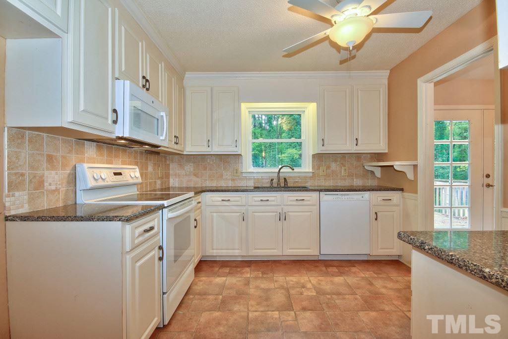 7609 Rambeau Circle Raleigh, NC 27613 - Photo 8 of 22 a kitchen with granite countertop a sink window and cabinets
