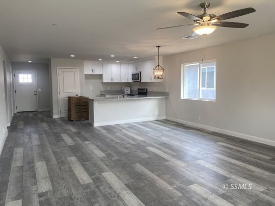 1405 Porter Street Ridgecrest, CA 93555 - Photo 7 of 23 a view of a kitchen with a stove cabinets a ceiling fan and wooden floor