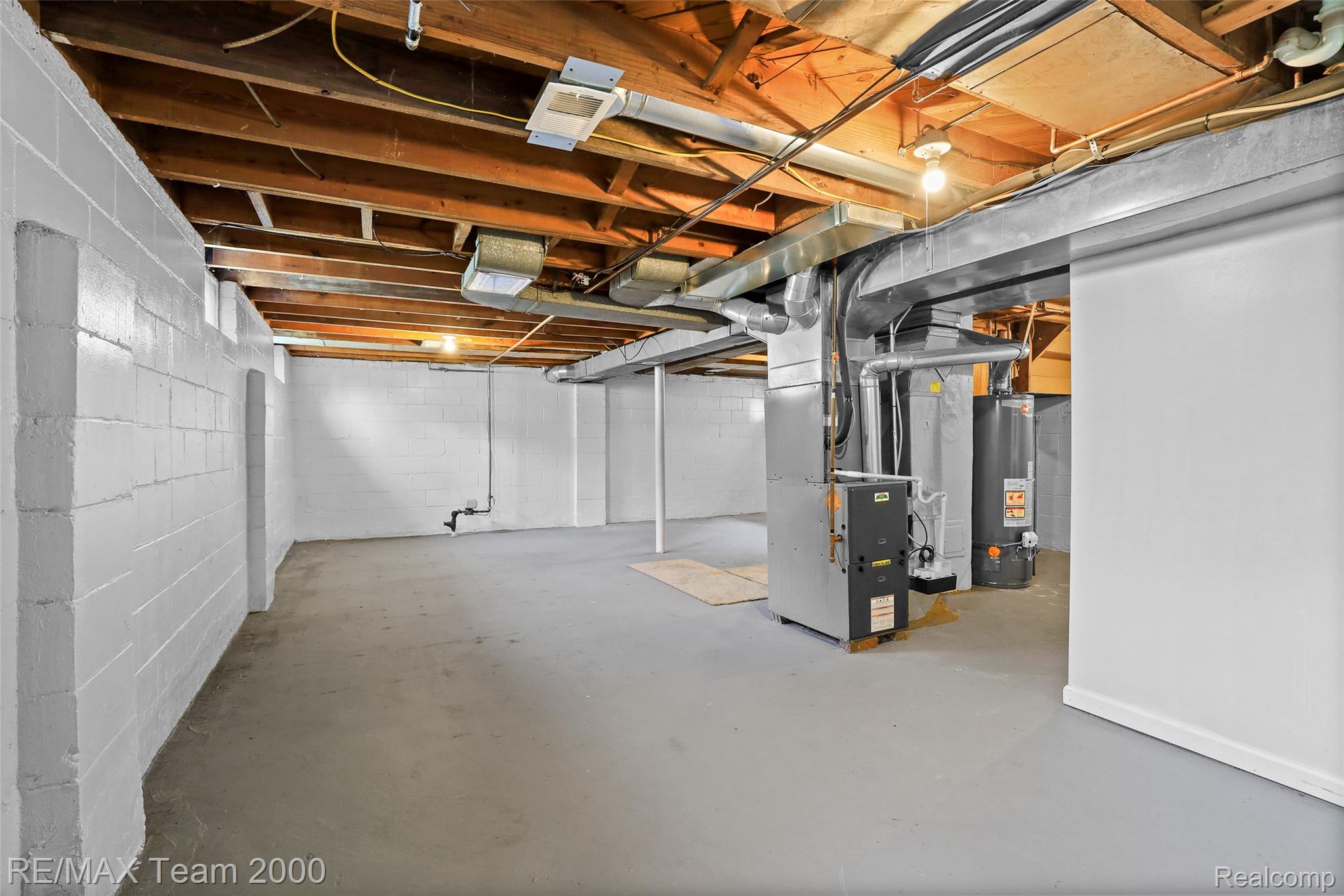 3130 Chestnut Street Dearborn, MI 48124 - Photo 24 of 30 Expansive unfinished basement featuring painted concrete block walls, exposed wood ceiling joists, and a concrete floor