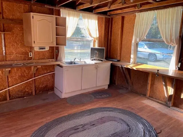 a kitchen with granite countertop a refrigerator and a wooden cabinets