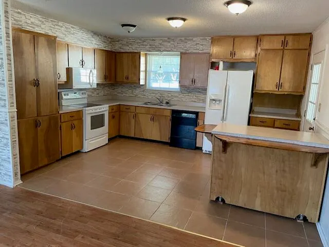 a large kitchen with stainless steel appliances granite countertop a refrigerator and a stove top oven