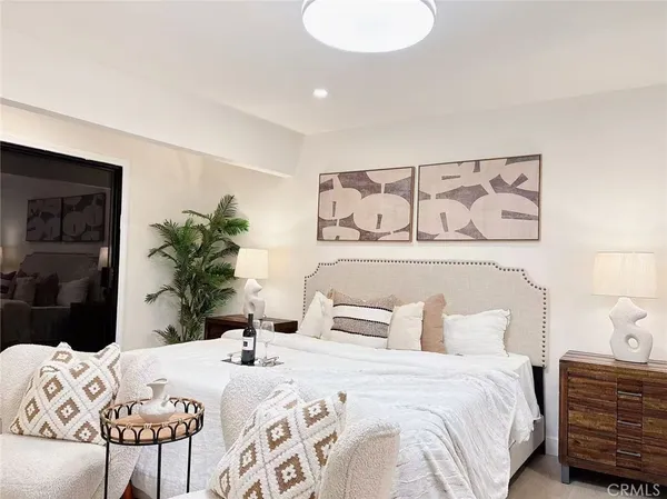 a bedroom with a bed and a potted plant