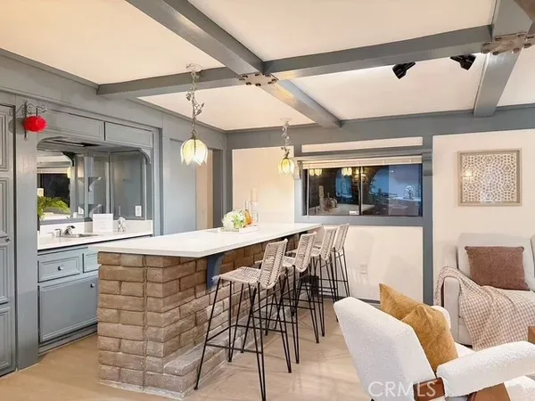 a dining hall with stainless steel appliances kitchen island granite countertop a dining table and chairs