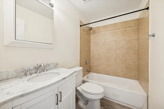 a bathroom with a granite countertop sink toilet and shower