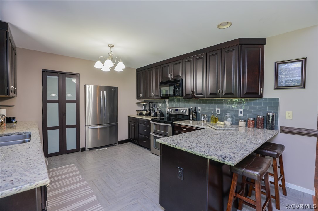 11706 Corte Castle Road Chesterfield, VA 23838 - Photo 12 of 44 a kitchen with granite countertop a refrigerator a stove a sink and a counter space