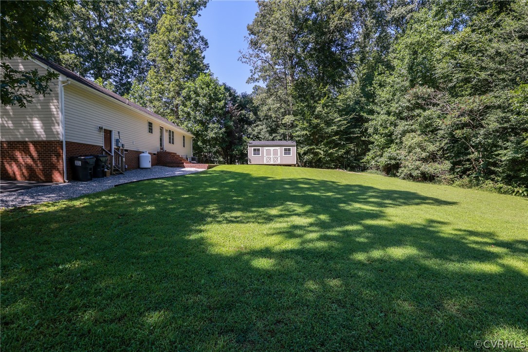 11706 Corte Castle Road Chesterfield, VA 23838 - Photo 36 of 44 a backyard of a house with table and chairs potted plants and large tree