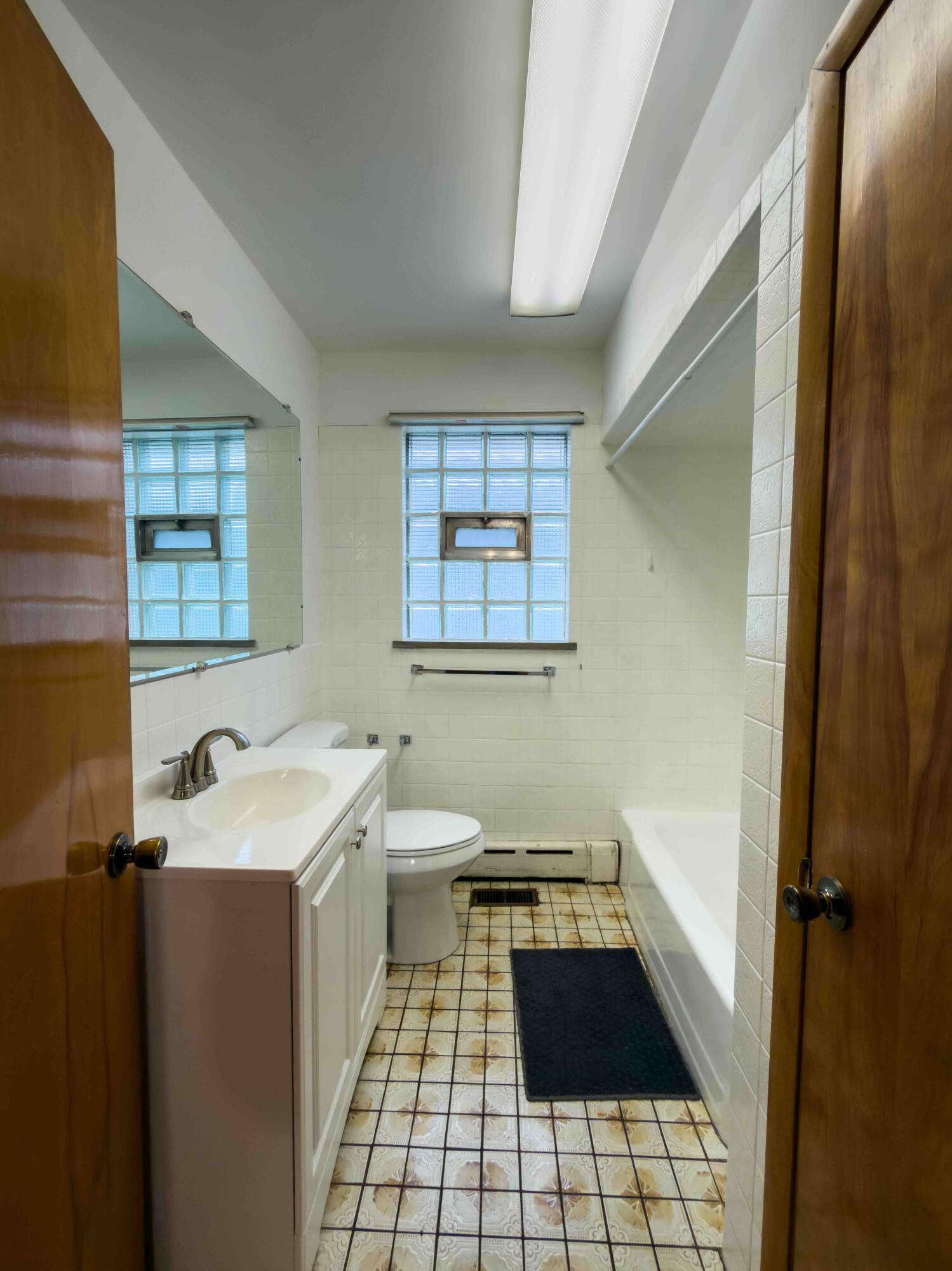 1218 120th Street Whiting, IN 46394 - Photo 14 of 25 a bathroom with a sink a toilet and window