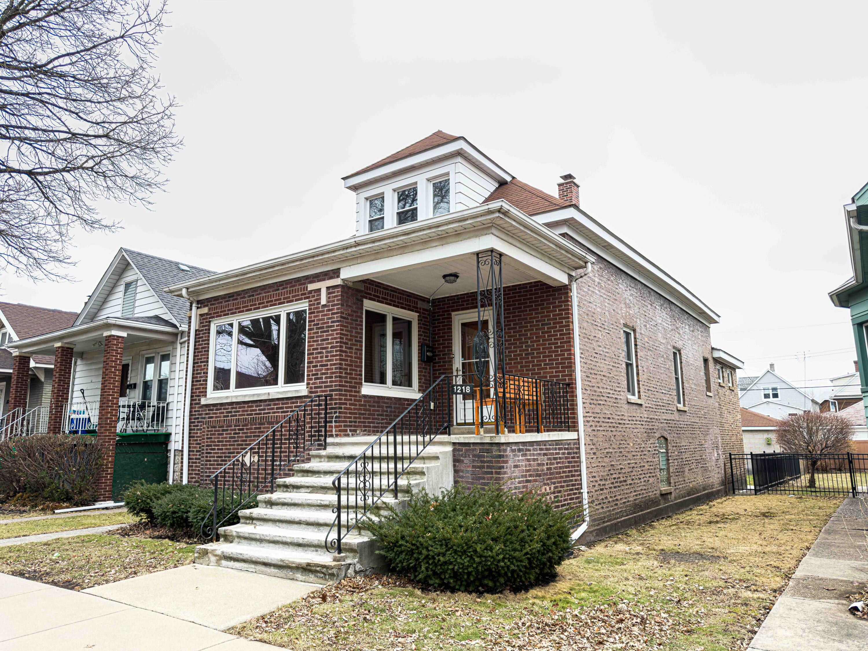 1218 120th Street Whiting, IN 46394 - Photo 2 of 25 a front view of a house with a garden