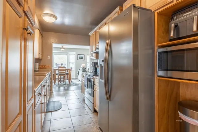 a kitchen with granite countertop a refrigerator and furniture