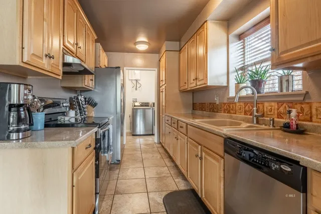 a kitchen with stainless steel appliances granite countertop a sink a stove and a refrigerator