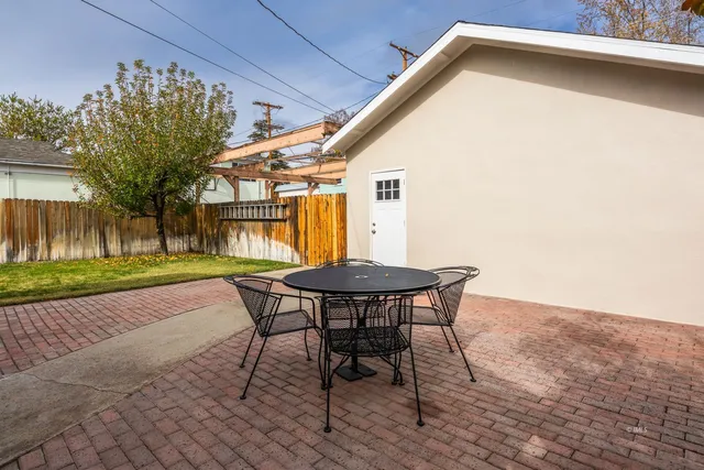 a backyard of a house with barbeque oven table and chairs