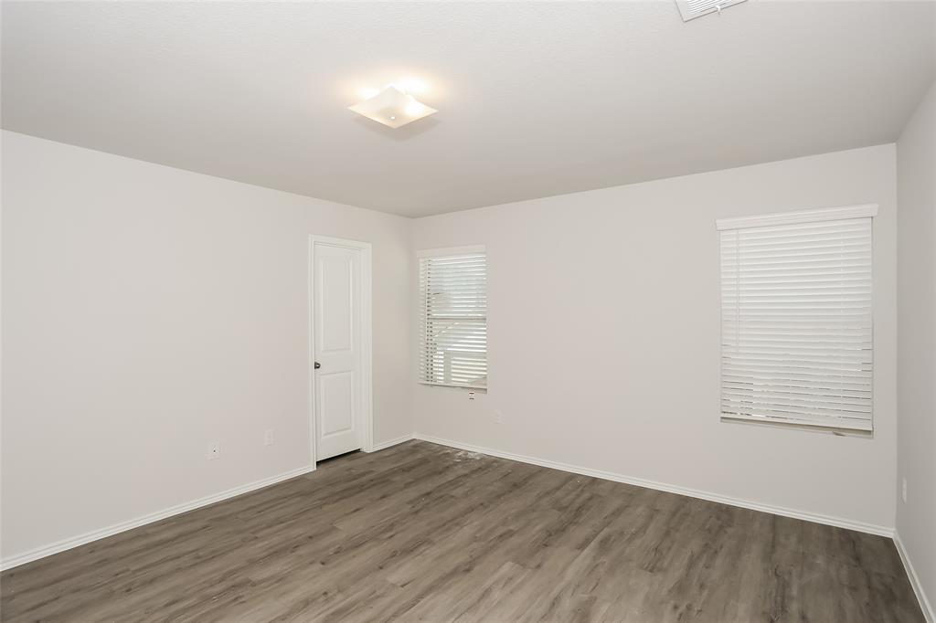 5512 Willamette Drive Fort Worth, TX 76119 - Photo 5 of 14 an empty room with wooden floor and windows