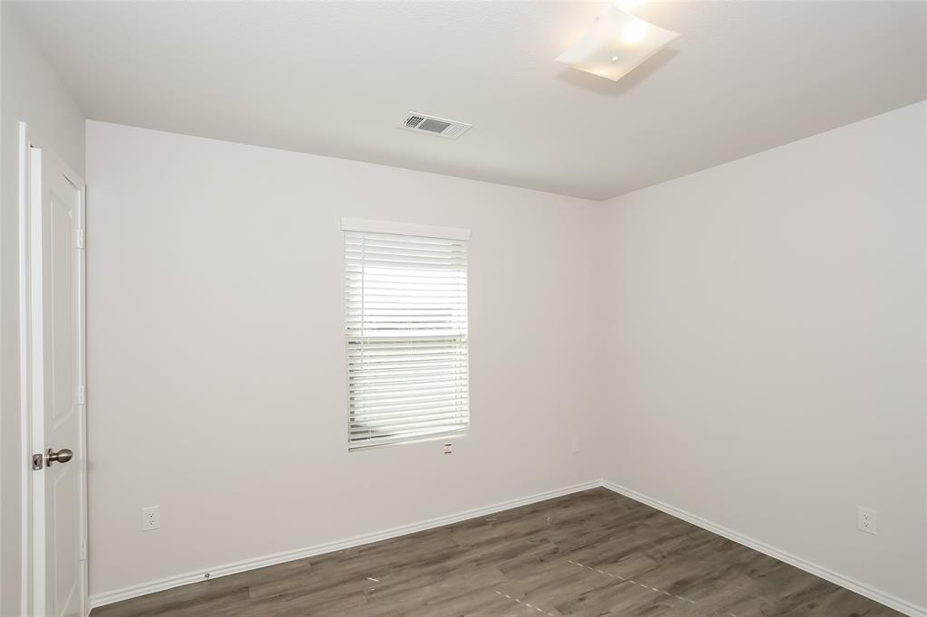 5512 Willamette Drive Fort Worth, TX 76119 - Photo 8 of 14 an empty room with wooden floor and windows