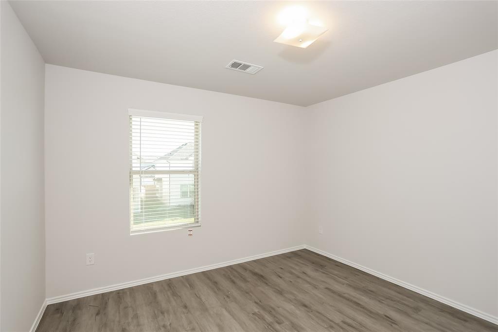 5512 Willamette Drive Fort Worth, TX 76119 - Photo 9 of 14 an empty room with wooden floor and windows