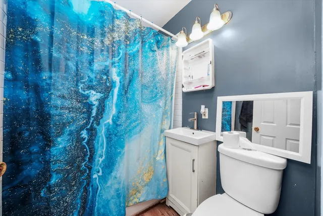 a bathroom with a toilet sink and mirror