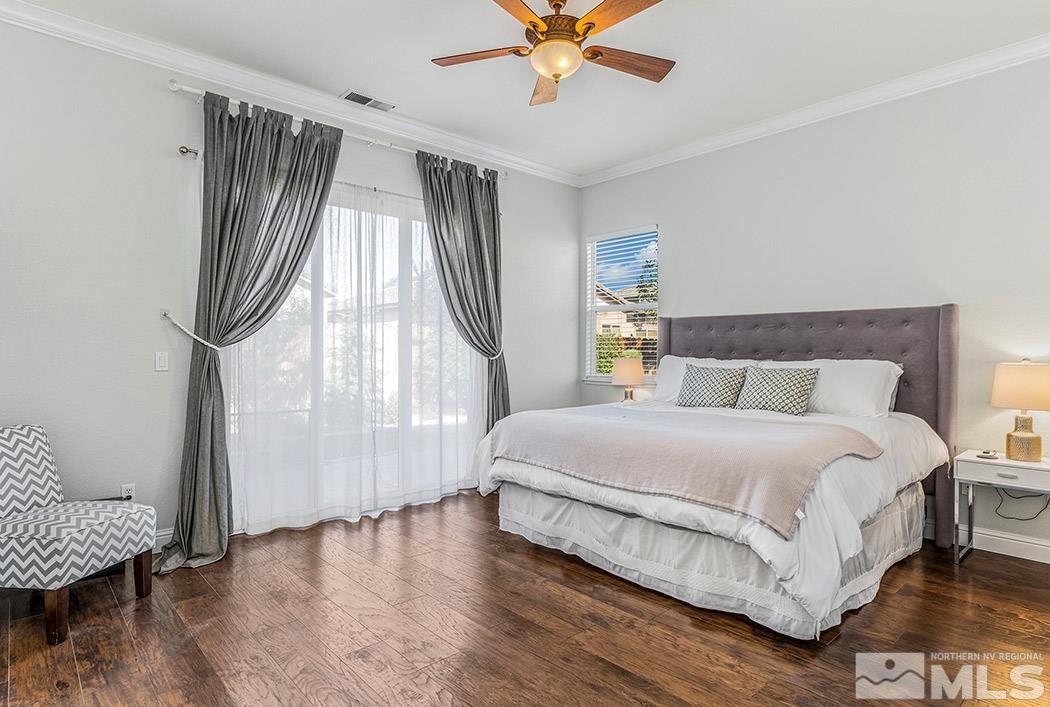 10589 Twin Bridges Way Reno, NV 89521 - Photo 16 of 34 a spacious bedroom with a bed and a chandelier