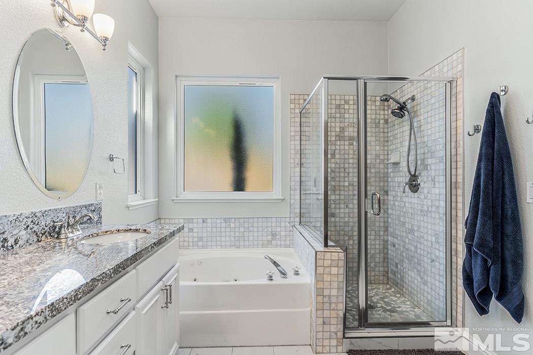 10589 Twin Bridges Way Reno, NV 89521 - Photo 18 of 34 a bathroom with a granite countertop sink a mirror a vanity and shower