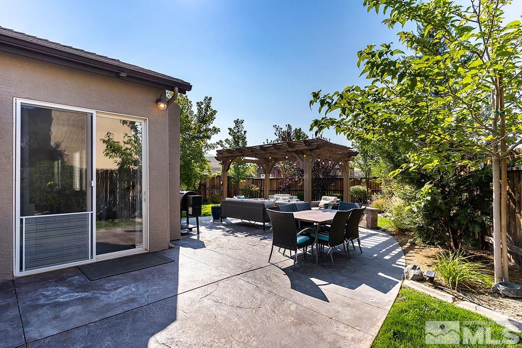 10589 Twin Bridges Way Reno, NV 89521 - Photo 32 of 34 a view of a patio with table and chairs potted plants and floor to ceiling window