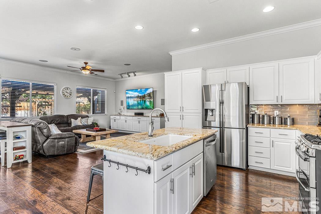 10589 Twin Bridges Way Reno, NV 89521 - Photo 7 of 34 a kitchen that has a lot of cabinets a sink and a refrigerator