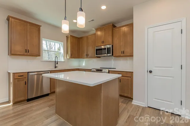 a kitchen with stainless steel appliances granite countertop a sink stove and microwave