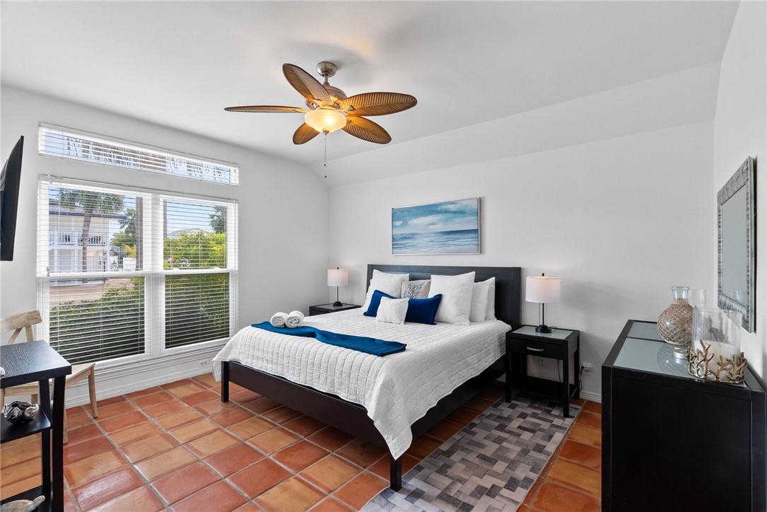 21 Flamingo Road Rockport, TX 78382 - Photo 17 of 30 a bedroom with a bed and a chandelier