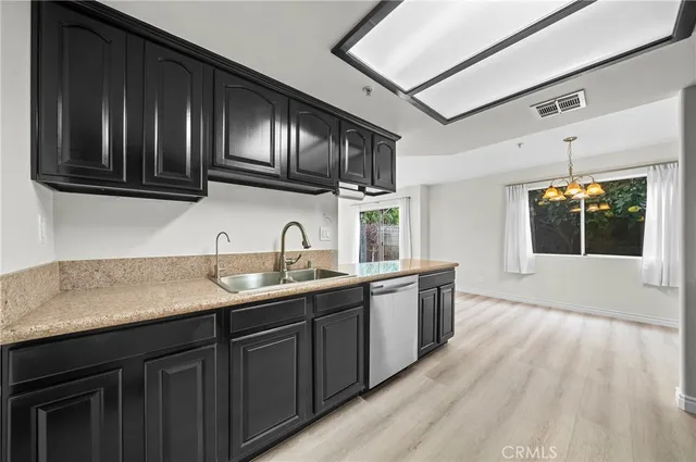 a kitchen with stainless steel appliances granite countertop wooden cabinets a sink and dishwasher