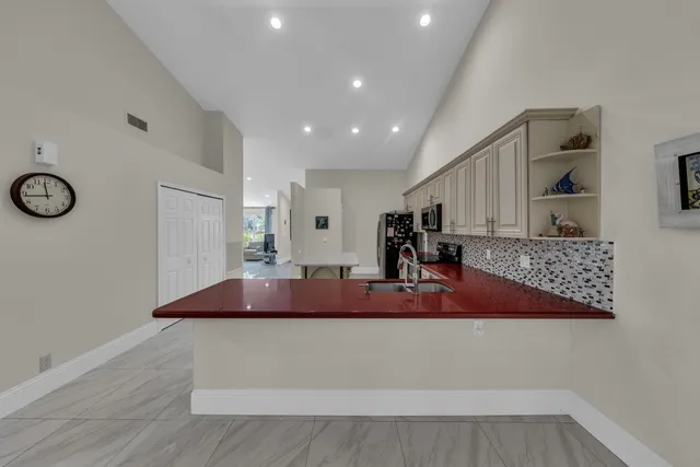 a kitchen with stainless steel appliances granite countertop a sink and a refrigerator