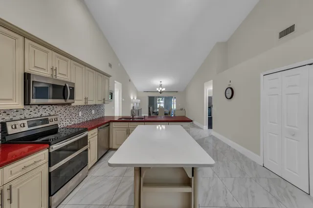 a large kitchen with stainless steel appliances a large counter top space