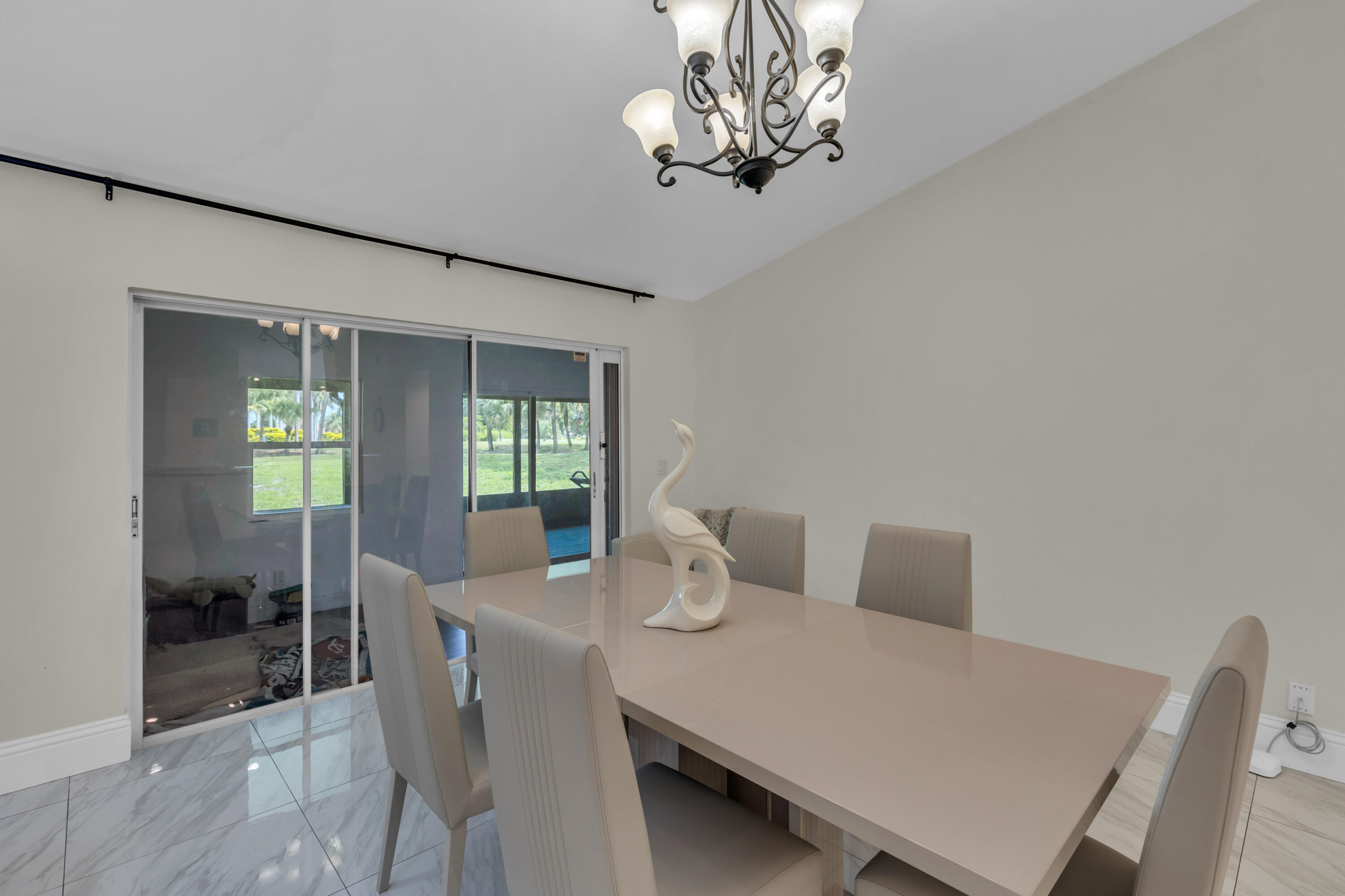 19623 Back 9 Drive Boca Raton, FL 33498 - Photo 17 of 24 a view of a dining room with furniture wooden floor and chandelier