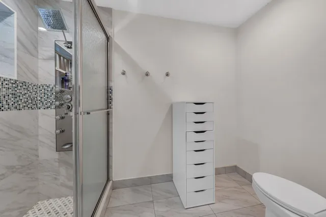 a bathroom with a shower toilet and sink