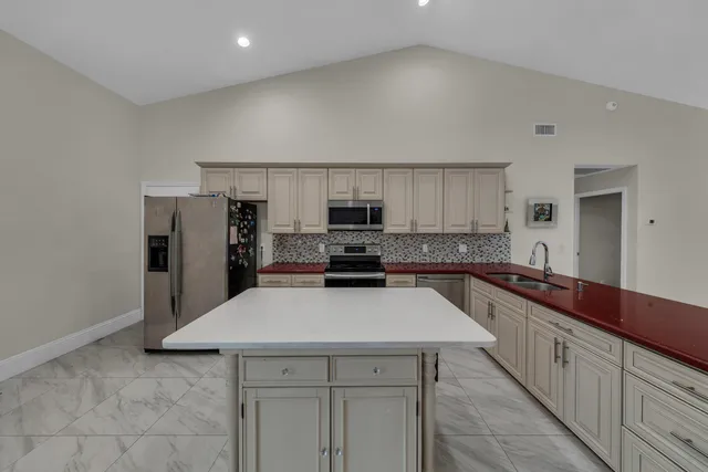 a kitchen with granite countertop a sink stove and refrigerator