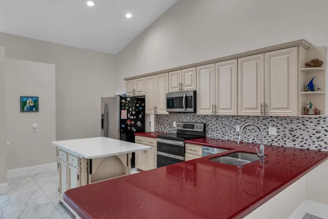 a kitchen with stainless steel appliances granite countertop a sink a stove a microwave a counter top space and cabinets