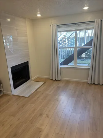 an empty room with wooden floor and fireplace