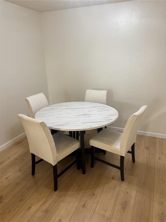 2200 East Trinity Mills Road, Unit 715 Carrollton, TX 75006 - Photo 12 of 31 a view of a dining room with furniture and wooden floor