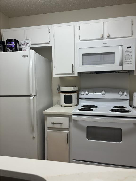 2200 East Trinity Mills Road, Unit 715 Carrollton, TX 75006 - Photo 20 of 31 a kitchen with stainless steel appliances white cabinets and white appliances