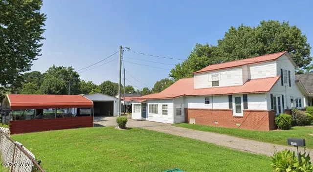 a front view of a house with a garden and yard