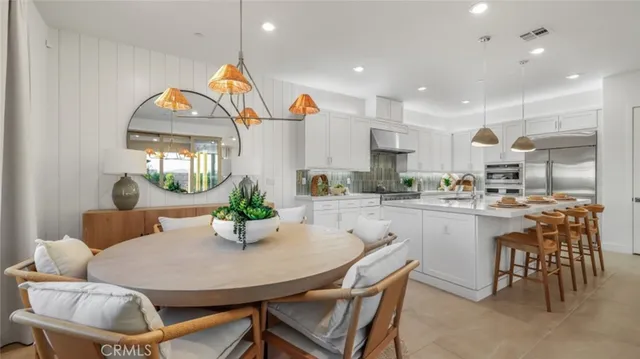 a kitchen with kitchen island a dining table and chairs