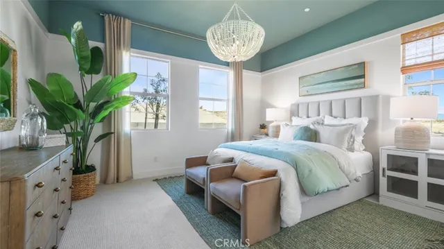 a spacious bedroom with a bed and a chandelier