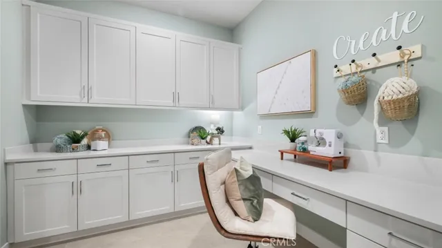 a view of a workspace with furniture and a window