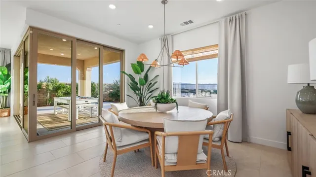 a dining room with furniture a chandelier and wooden floor