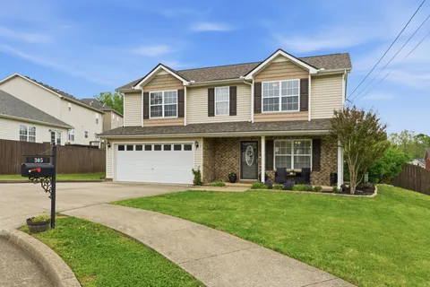 a front view of a house with a yard and trees