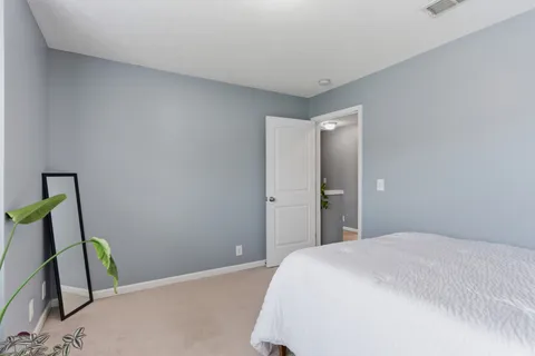 a bedroom with a bed and potted plant