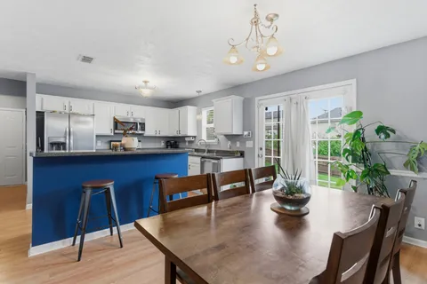 a kitchen with a table chairs refrigerator and cabinets